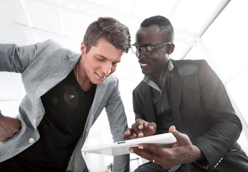 two employees use a digital tablet to analyze new data.people and technology