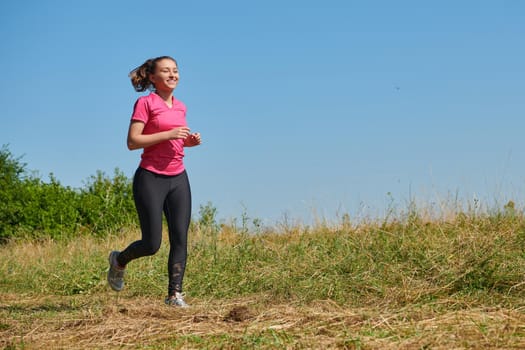 woman  jogging in a healthy lifestyle on a fresh mountain air at beautiful sunny summer nature