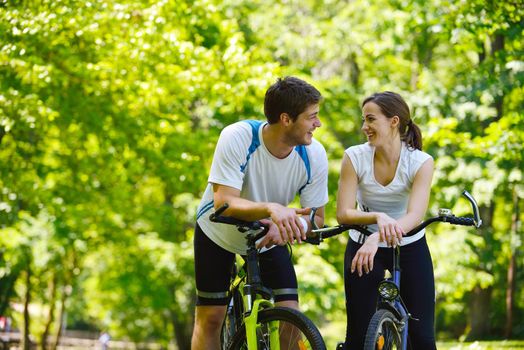 Happy couple riding bicycle outdoors, health lifestyle fun love romance concept