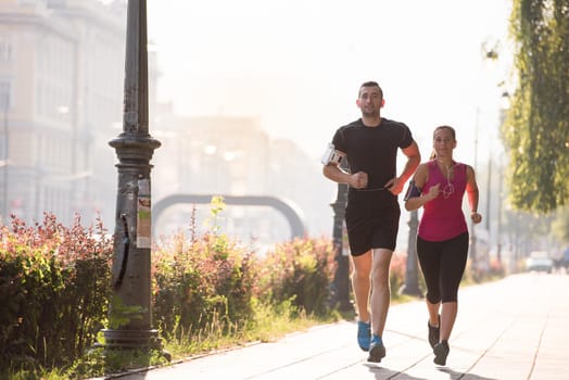 urban sports, healthy young couple jogging  in the city at sunny morning