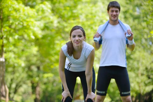 young health couple doing stretching exercise relaxing and warm up after jogging and running in park