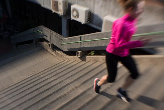 sporty woman running onsteps at early morning jogging