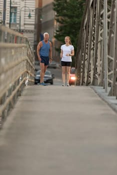 healthy mature couple jogging in the city  at early morning with sunrise in background