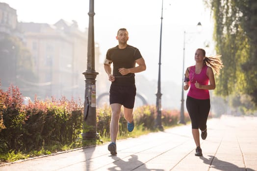 urban sports, healthy young couple jogging  in the city at sunny morning