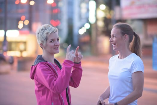 jogging couple warming up and stretching before morning running in the city