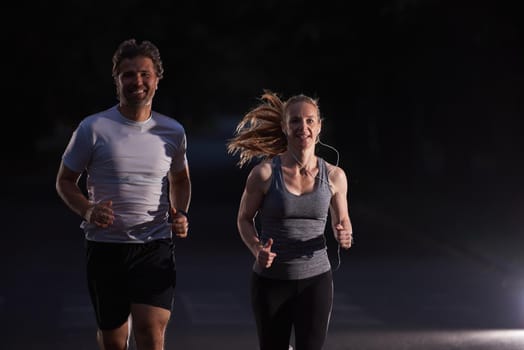 urban sports, healthy couple jogging in the city at early morning in night