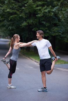 jogging couple warming up and stretching before running