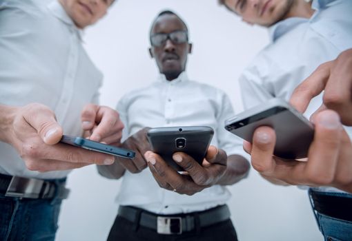 close up.three employees using their smartphones.people and technology