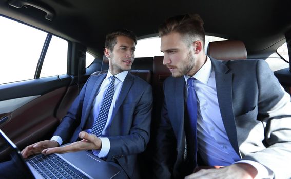 business colleagues use a laptop in the car.people and technology