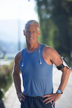 portrait of handsome senior jogging man while relaxing  and take break after morning run