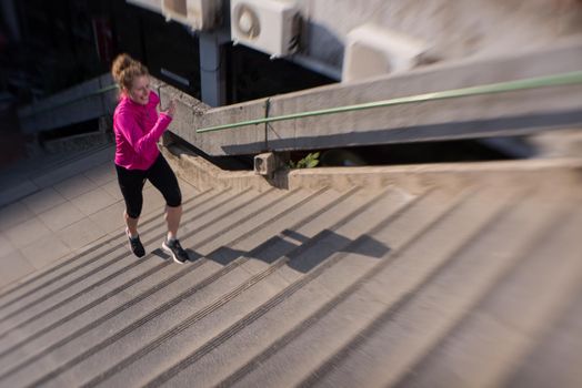 sporty woman running onsteps at early morning jogging