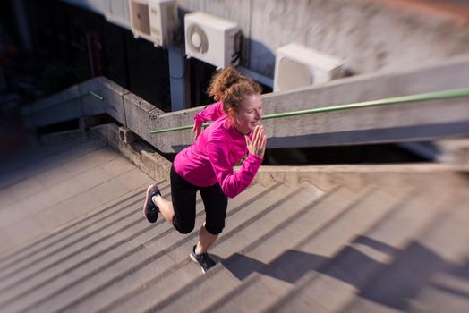 sporty woman running onsteps at early morning jogging