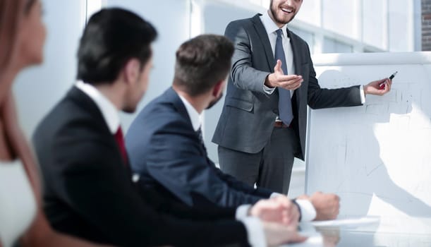 smiling businessman asks a question to colleagues at a business presentation .the concept of teamwork