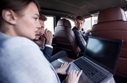 business team uses a laptop to work in the car.people and technology