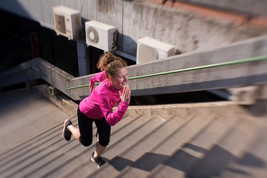 sporty woman running onsteps at early morning jogging