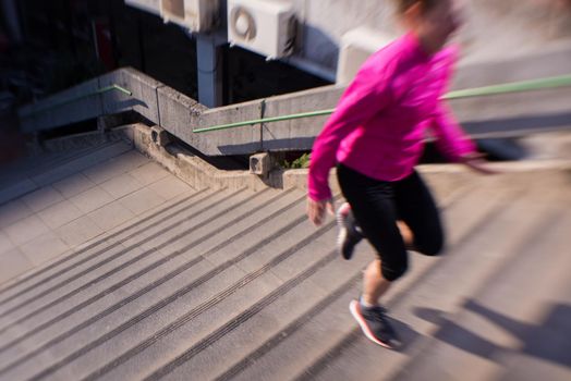 sporty woman running onsteps at early morning jogging