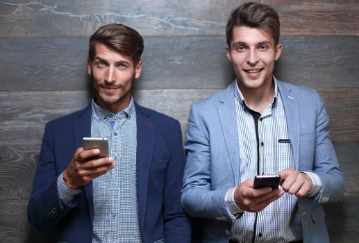 entrepreneurs hold smartphones in their hands and smile
