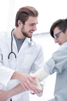 Orthopedist applying bandage onto patient's arm.doctor and the patient