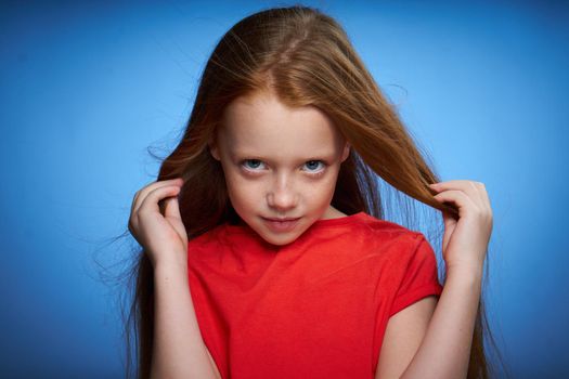 cheerful cute red-haired girl childhood blue background. High quality photo