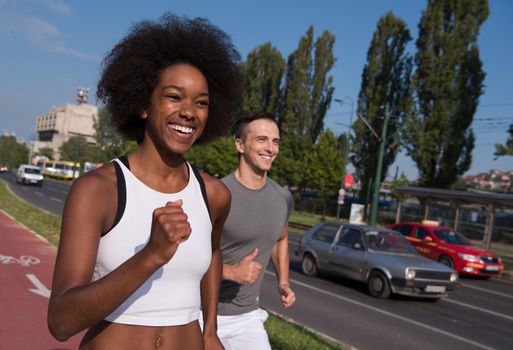 multiethnic group of young people on the jogging beautiful morning as the sun rises in the streets of the city