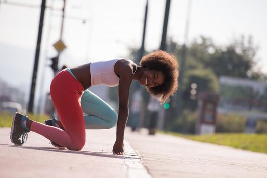 portrait of a young beautiful African American girl doing stretching beautiful summer morning on the streets of the city