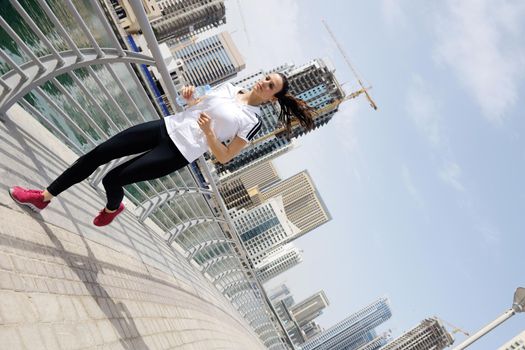 Running in city park. Woman runner outside jogging at morning with Dubai urban scene in background