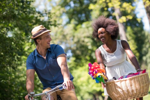 a young man and a beautiful African American girl enjoying a bike ride in nature on a sunny summer day