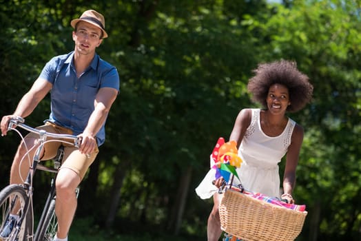 a young man and a beautiful African American girl enjoying a bike ride in nature on a sunny summer day