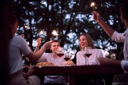 group of happy friends having picnic french dinner party outdoor during summer holiday vacation near the river at beautiful nature