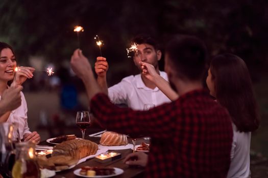 group of happy friends having picnic french dinner party outdoor during summer holiday vacation near the river at beautiful nature