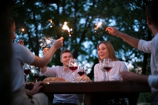 group of happy friends having picnic french dinner party outdoor during summer holiday vacation near the river at beautiful nature