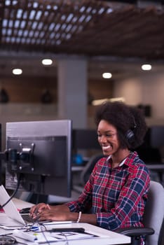 portrait of a young successful African American beautiful woman who enjoys spending a quality and joyful time while working in a large modern office