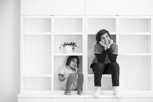 happy young boys are having fun while posing on a shelf in a new modern home