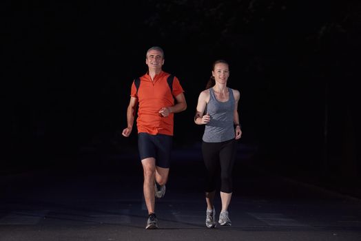 urban sports, healthy couple jogging in the city at early morning in night