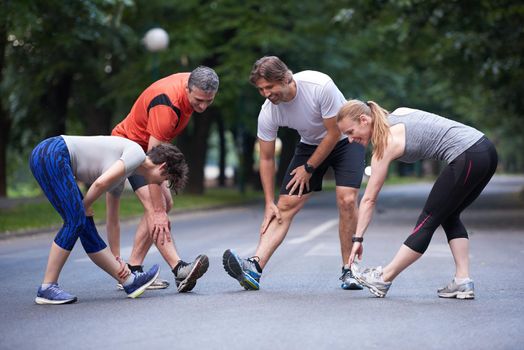 jogging people group stretching in park before training