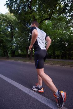 healthy athlete man jogging at morning on empty  roat in the city