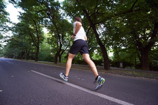 healthy athlete man jogging at morning on empty  roat in the city