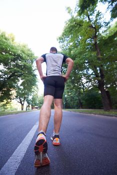 healthy athlete man jogging at morning on empty  roat in the city