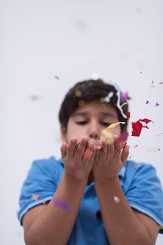 Happy kid celebrating party with blowing confetti