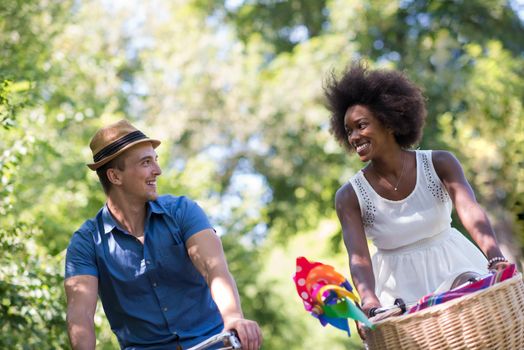 a young man and a beautiful African American girl enjoying a bike ride in nature on a sunny summer day