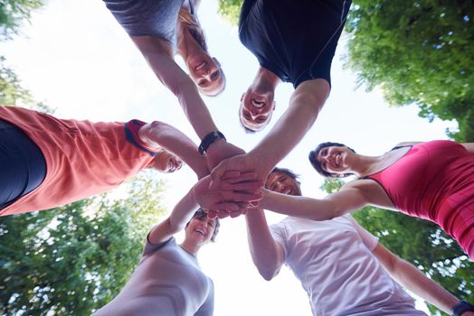 jogging people group, friends have fun,  hug and stack hands together after training