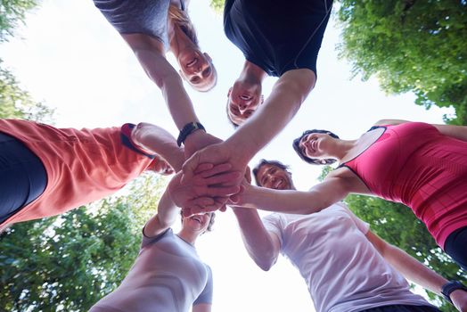 jogging people group, friends have fun,  hug and stack hands together after training