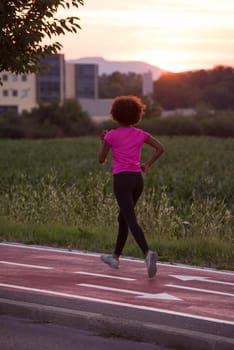 young beautiful African American woman enjoys running outside beautiful summer evening in the city