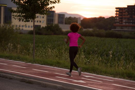 young beautiful African American woman enjoys running outside beautiful summer evening in the city