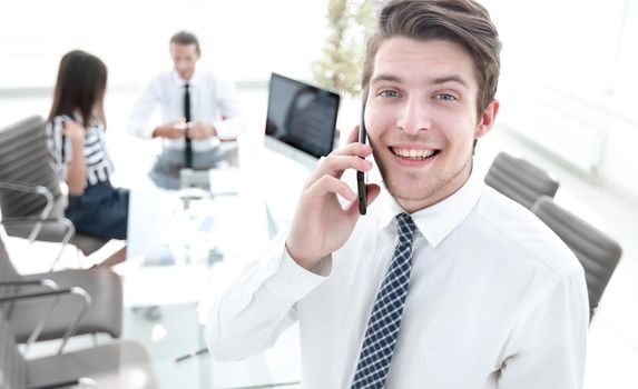 closeup.businessman talking on smartphone in office