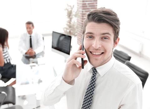 closeup.businessman talking on smartphone in office