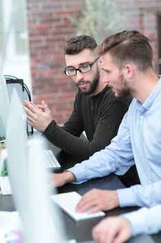 business colleagues talk, sitting at a computer table.people and technology