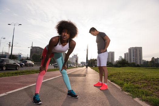 multiethnic group of young people on the jogging beautiful morning as the sun rises in the streets of the city