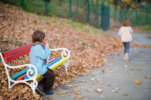 realationship break concept with couple of kids  in park on autumn cloudy day