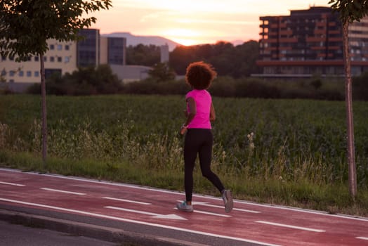 young beautiful African American woman enjoys running outside beautiful summer evening in the city